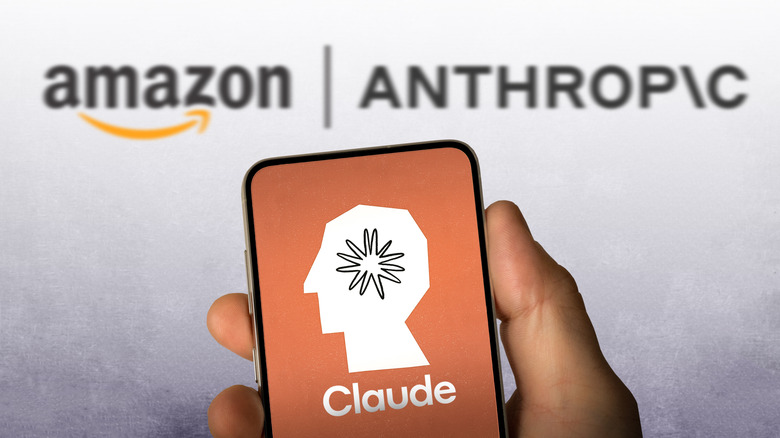 A hand holding smartphone with Claude logo on screen, Amazon and Anthropic logos in the background