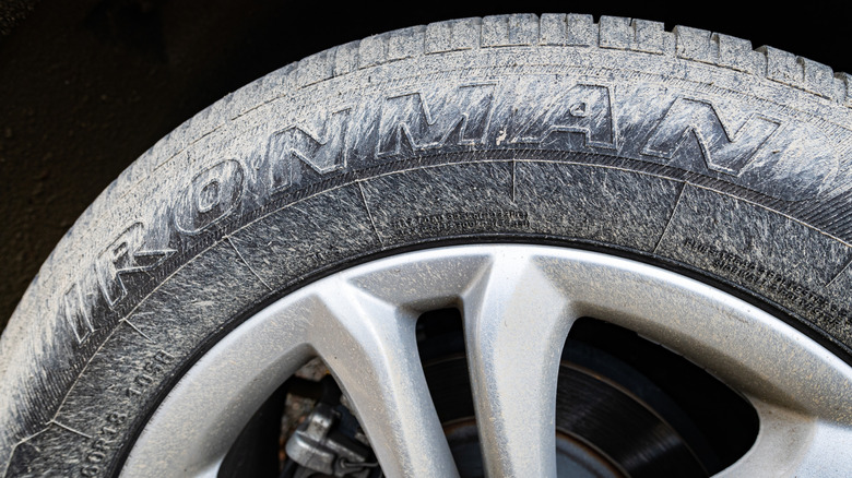 Photo of a Ford Edge SUV Ironman tire with grey mud splattered on it.