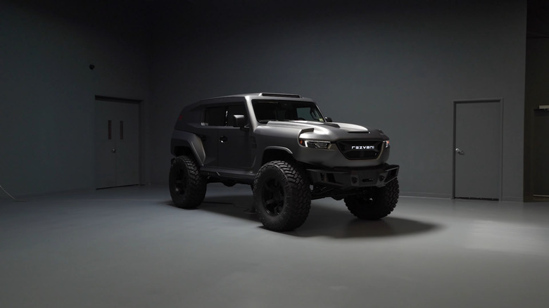 A Rezvani Tank on display in a dimly lit room