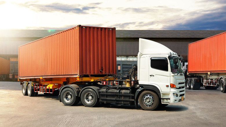 Semi trailer trucks in the parking lot of a warehouse