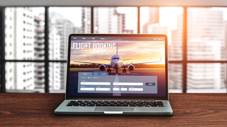 A laptop shows a flight booking page