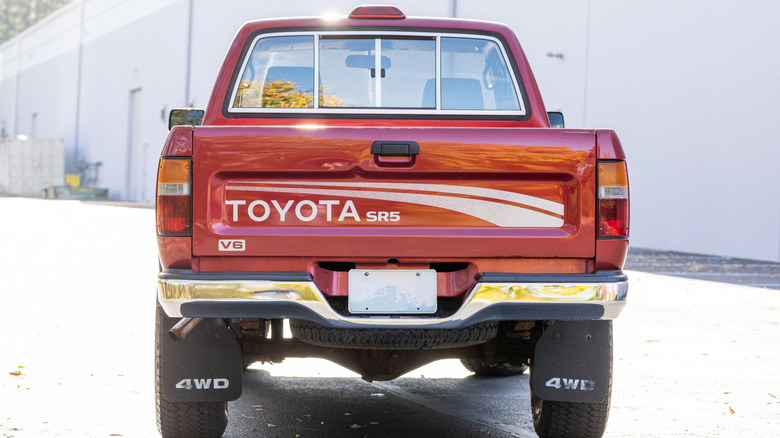 Rear shot of a red Toyota Tacoma SX V6 Xtracab parked in front of a building
