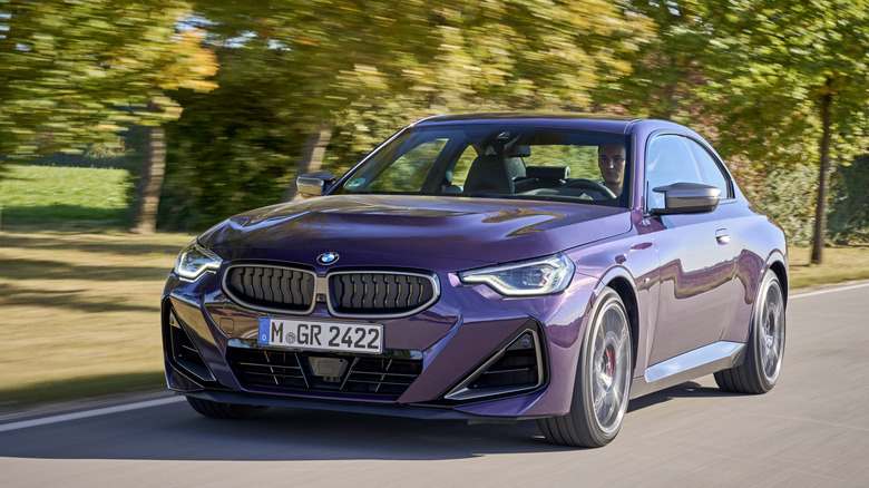 2025 BMW M240i driving down road, front-left 3/4 view