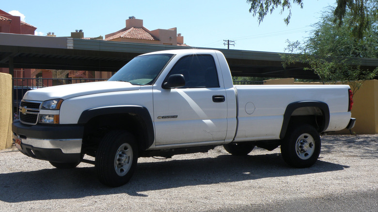 A white GMT880 Chevrolet Silverado 2500HD parked on a street on a sunny day, front 3/4 view
