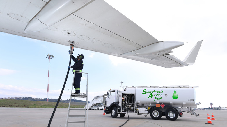 technician refuels airplane with sustainable fuel