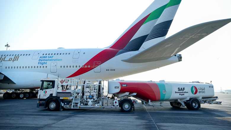 a new emirates plane at a demonstration flight with a fuel truck in the foreground