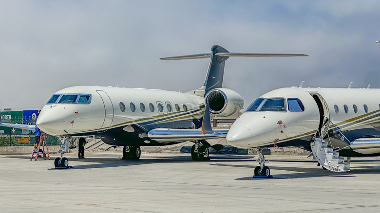 Two parked private jets with rear-mounted engines