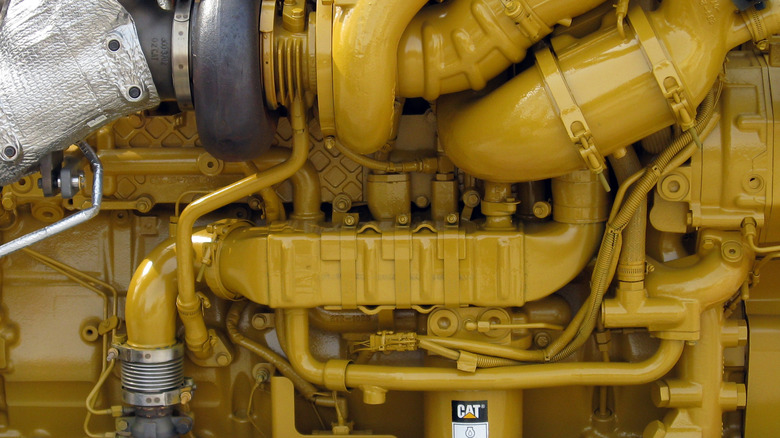 Closeup of the side of a yellow Caterpillar C15 ACERT engine