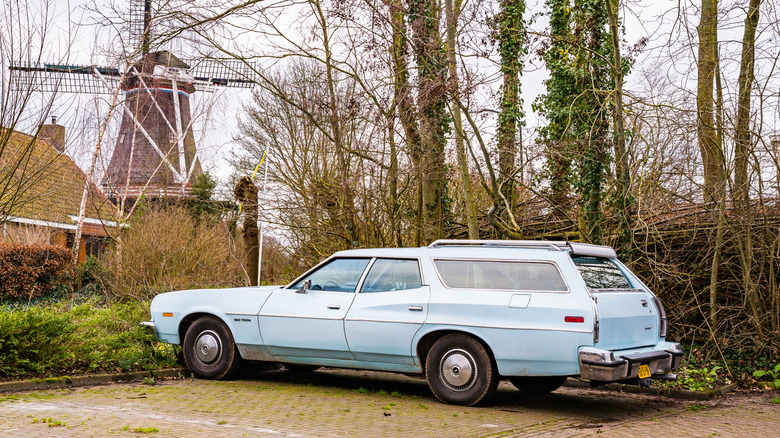 Driver side view of Ford Gran Torino wagon parked with windmill in the background