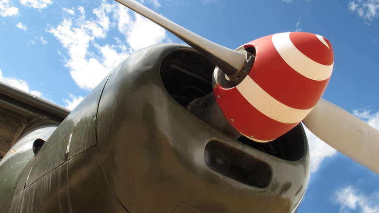 A red-and-white spinner spiral on the nose cone of a vintage fighter plane.