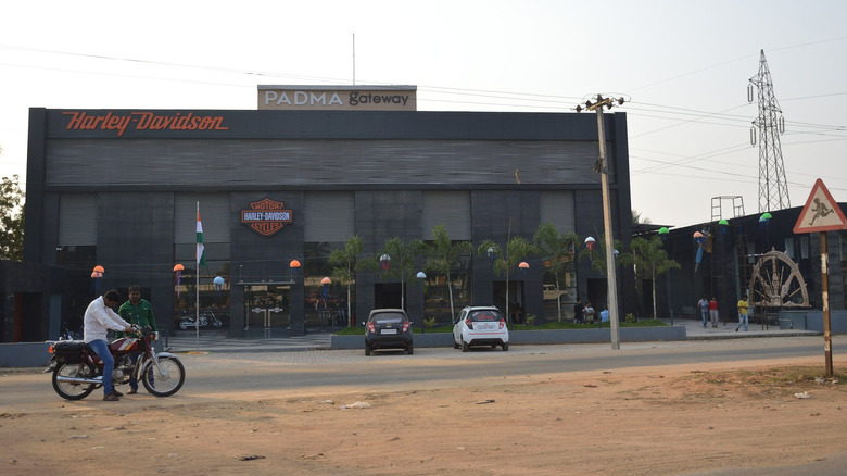 motorbike on a sandy road outside a Harley Davidson branded building