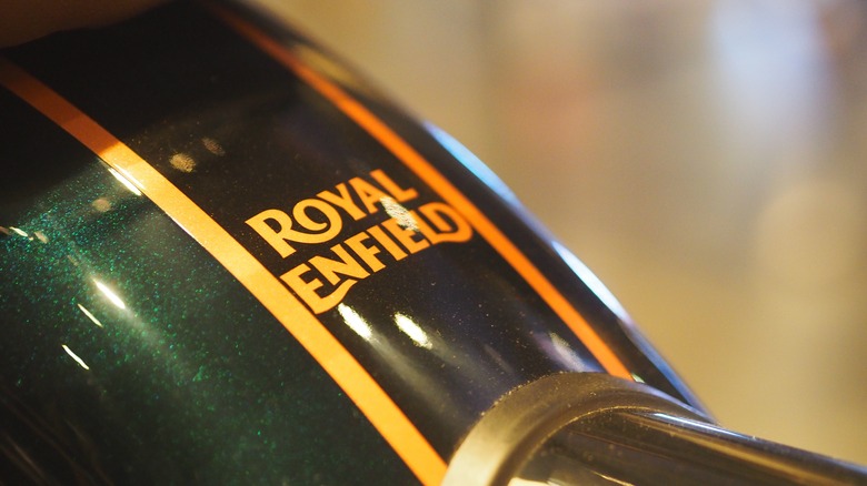 A green an gold Royal Enfield Classic fuel tank.