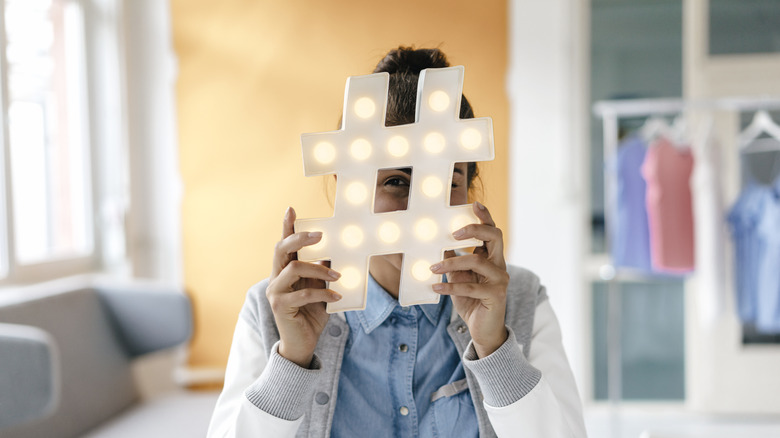 winking woman whose face is hid behind a hashtag symbol