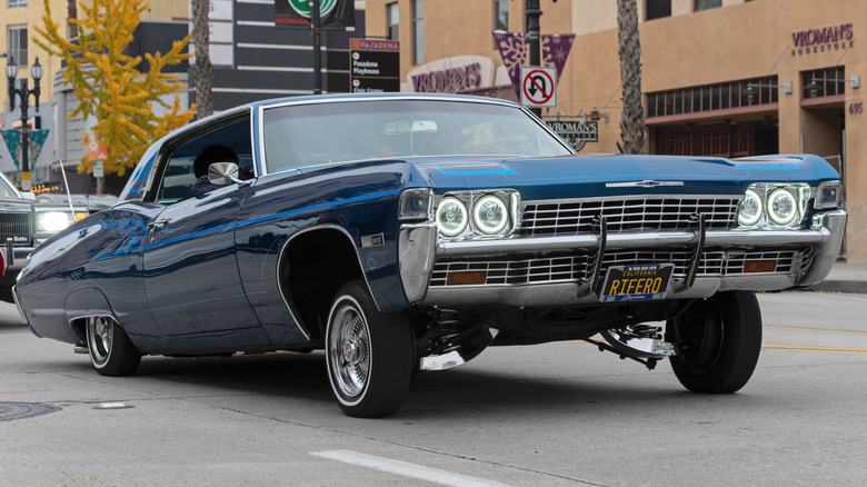 A blue lowrider cruising on the street