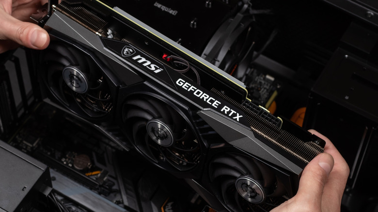 Person installing an Nvidia GeForce RTX graphics card in a PC