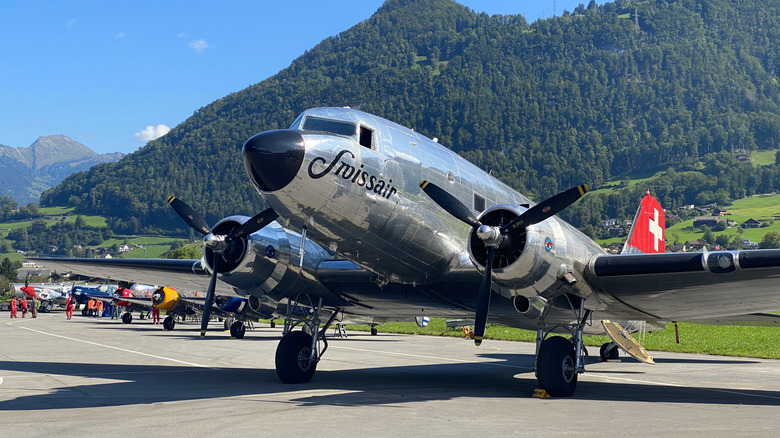 parked aircraft with aluminium fuselage and black nose