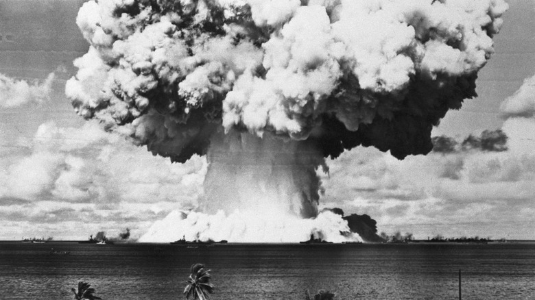 The blast from the Baker nuclear bomb test during Operation Crossroads at Bikini Atoll on July 25, 1946, showing naval warships impacted by the explosion.