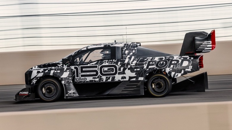 Side view of a Ford F150 Lightning SuperTruck EV in black-and-white campouflage on a test track