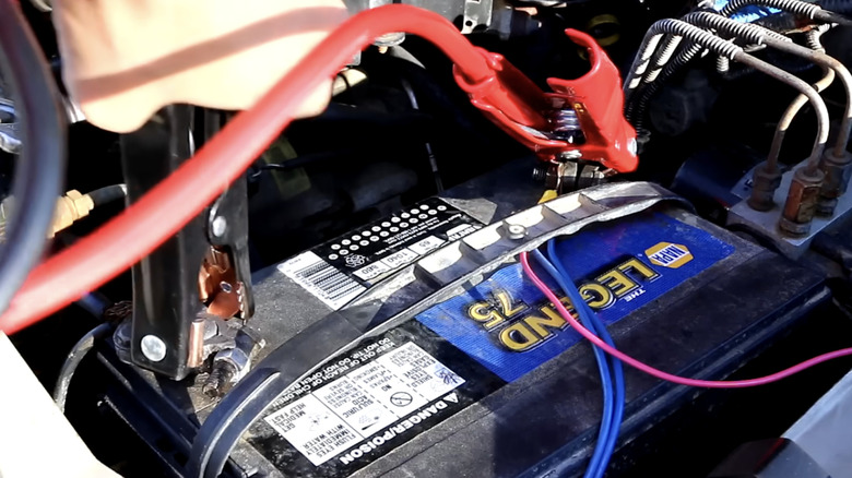 jumper cables being connected to car battery