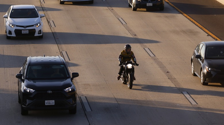 motorcyclist negotiating traffic on a freeway.