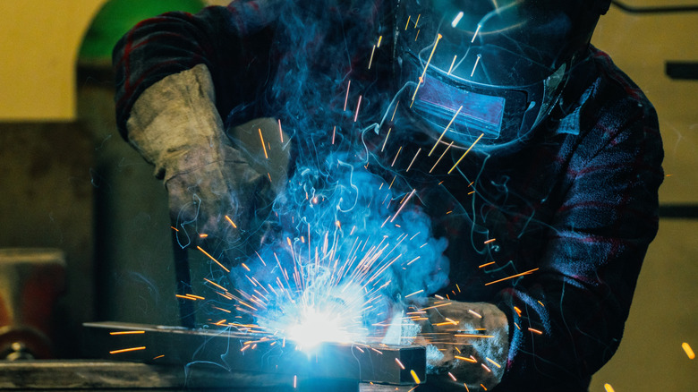 A person welding while wearing all safety gears
