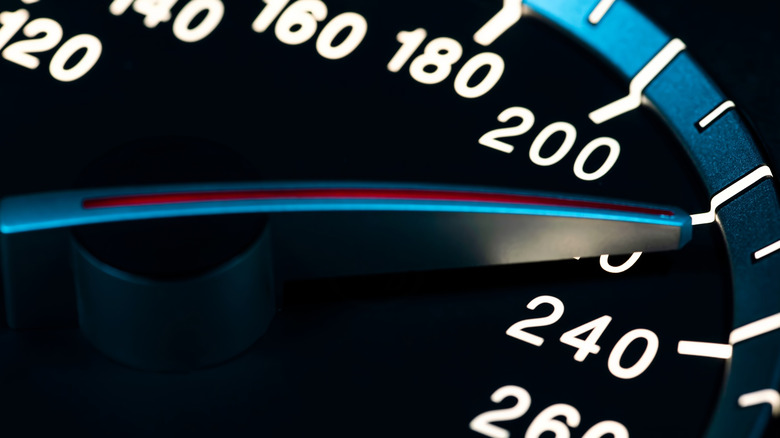 Car speedometer needle hitting the 220 mph mark