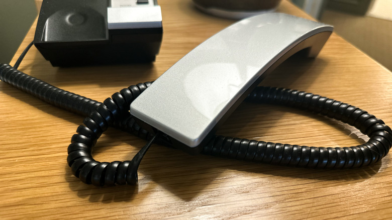 landline phone with coiled cord off the hook