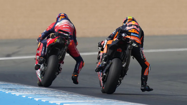 MotoGP riders sticking a leg out before a braking zone