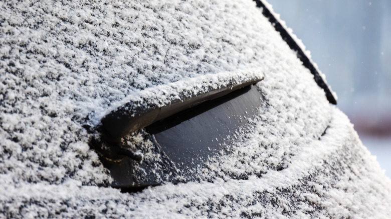 A close-up shot of a rear window and rear wiper covered in snow