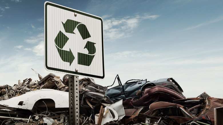A General Image Of A Scape Or Salvage Yard With A Recycle Sign In Front