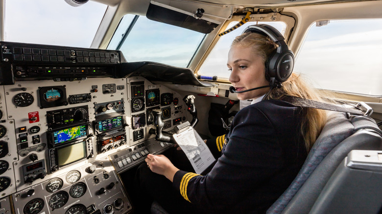 airplane pilot sitting in cockpit with a headset on