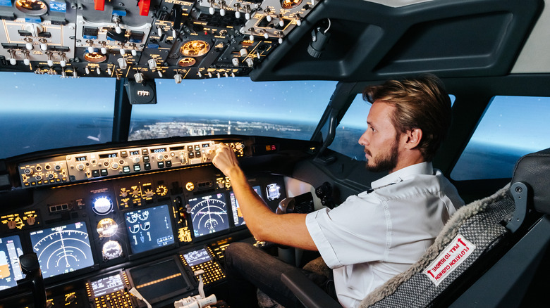 First officer making changes to flight controls in the cockpit of a Boeing jet