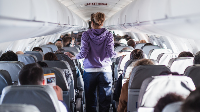 Passenger walking through plane cabin