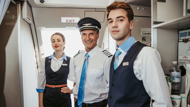Smiling aircrew in airplane cabin
