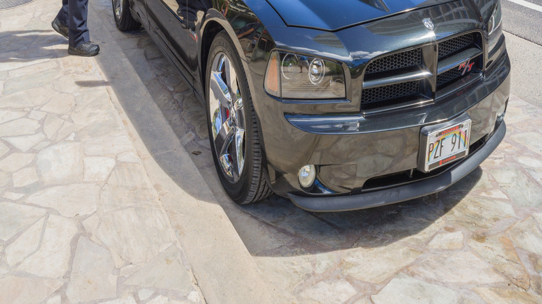 An Officer Standing Next To His Private Vehicle Used For Patrol