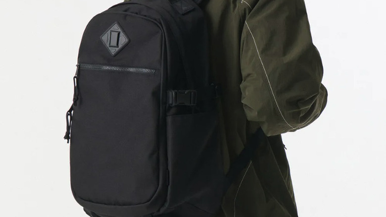 Person wearing black Musinsa standard backpack