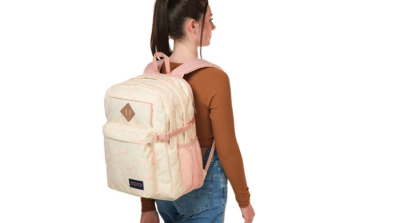 Person wearing off-white and pink Jansport Main Campus backpack