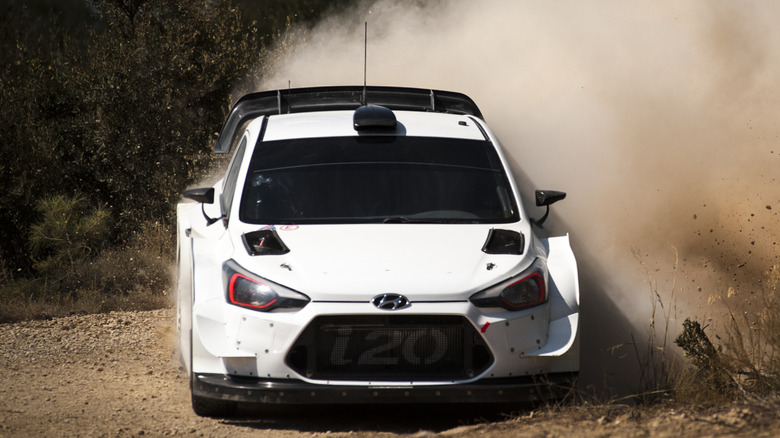 white Hyundai rally car kicking up dirt
