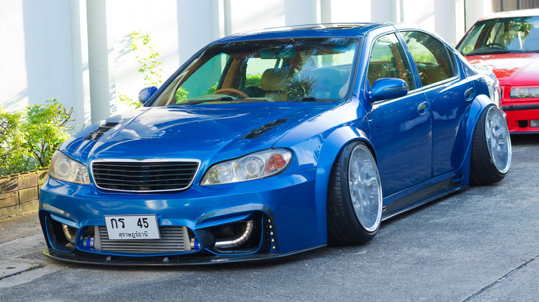 A blue car with extreme negative camber on the street, front 3/4 view
