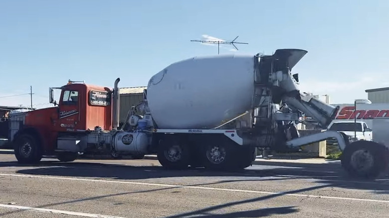 A cement truck with its tag axle down.