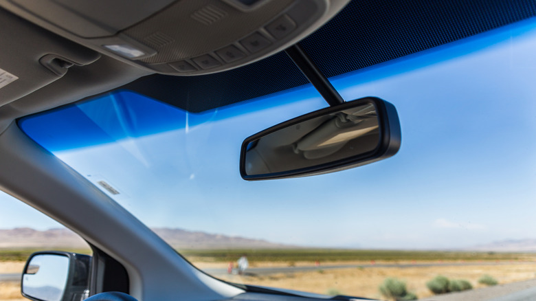 Interior view of a car windshield with a visible shade band near the top