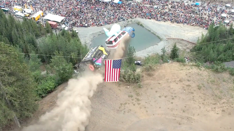 Decorated SUV jumping off cliff with trailer attached