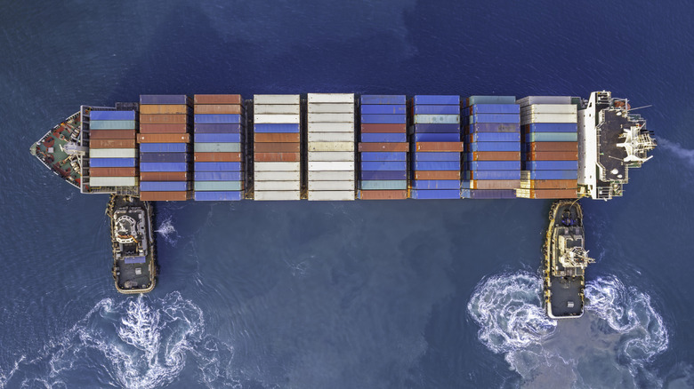 Tugboats Pushing A Container Ship Laterally
