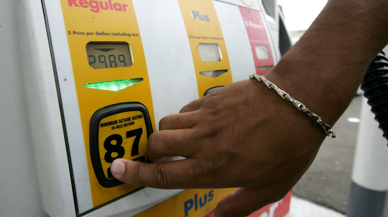 Hand choosing 87 octane gasoline at pump