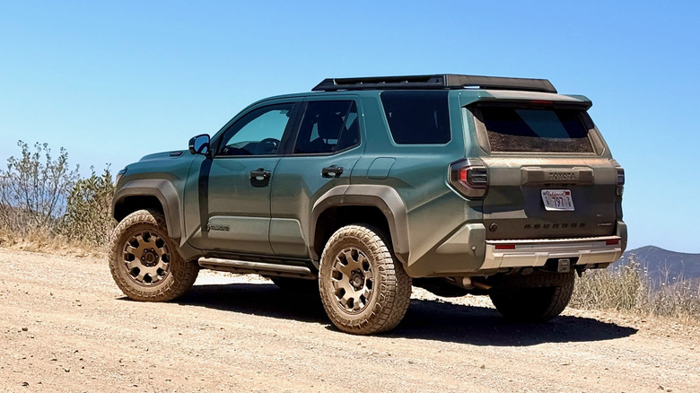 Rear view of a green 2025 Toyota 4Runner parked on a dirt trail
