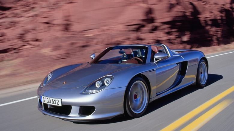 2004 Porsche Carrera GT driving down canyon road, front-left 3/4 view