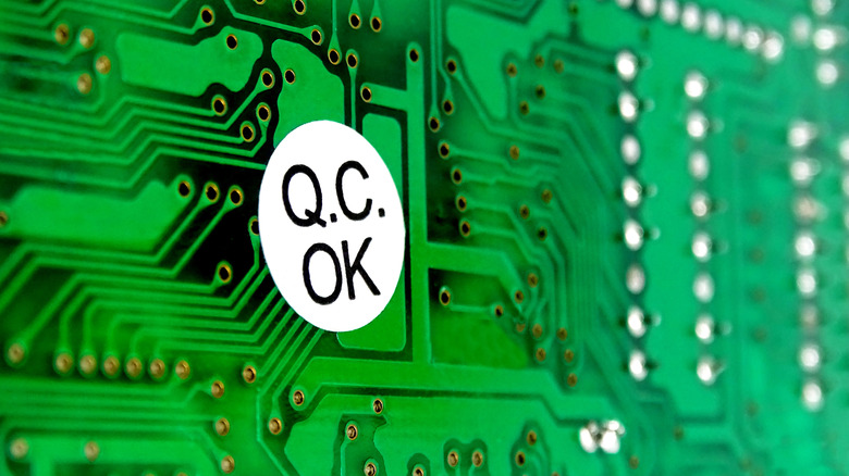 A Q.C. label stands out against a green computer hard drive