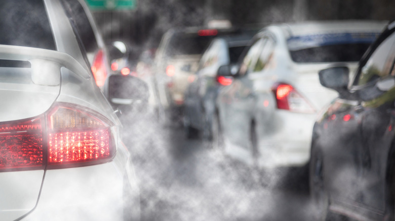 Cars in a traffic jam are surrounded by car exhaust