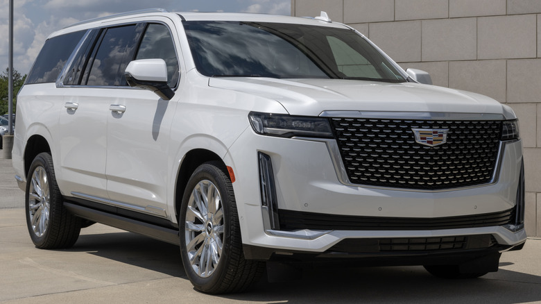 A light gray Cadillac Escalade in a parking lot.