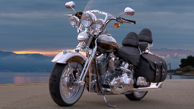 Angled sunset photo a of Harley with backrests for rider and pillion, a screen, saddlebags and lots of chrome